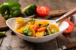 Verduras al vapor sobre un recipiente blanco con una cuchara