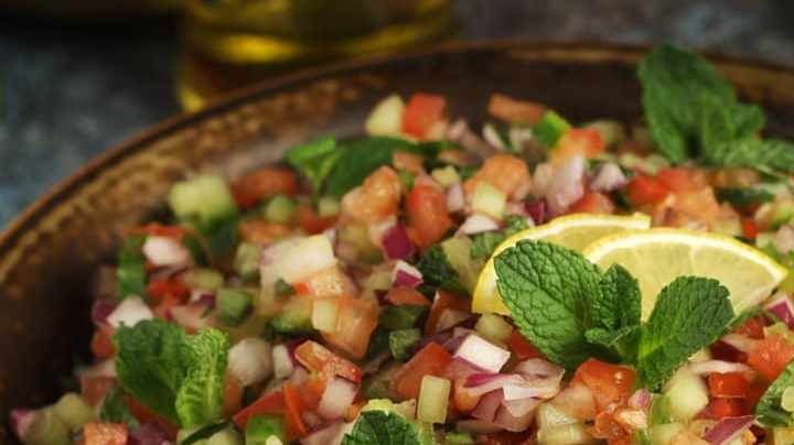 Ensalada de pepino con limón en una cazuela sobre una mesa gris