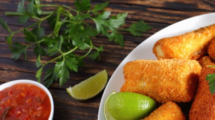 Merluza con costra de pan en un plato blanco