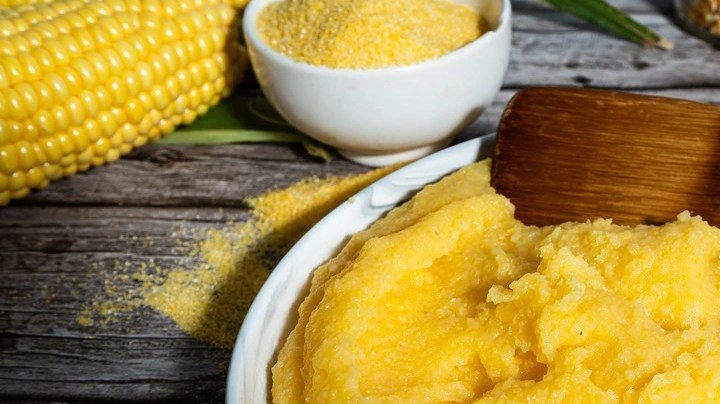 Polenta en un plato blanco sobre una mesa gris