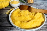 Polenta en un plato blanco sobre una mesa gris